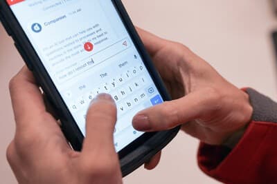 a close-up of hands holding a Target store device with a screen showing the new Store Companion technology