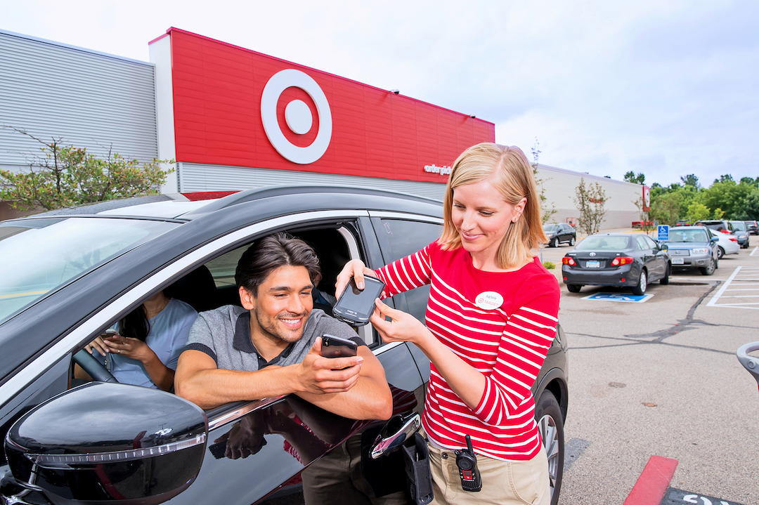 A Target Team Member is fulfilling a Drive Up order with a guest at their car.